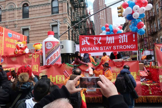 People display signs in support of Wuhan, China, at the center of the coronavirus outbreak, during the Lunar New Year parade, in Manhattan's Chinatown.